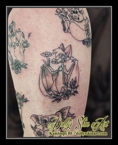 a woman's arm with tattoos on it and flowers in the center, including an angel