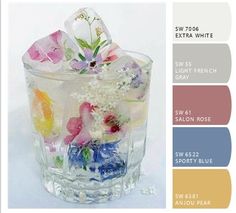 a glass filled with lots of different colored flowers