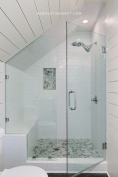 a white bathroom with a glass shower door