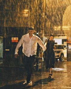 a man and woman walking in the rain