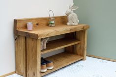 a wooden shelf with some shoes on it and a bunny statue next to the shelf