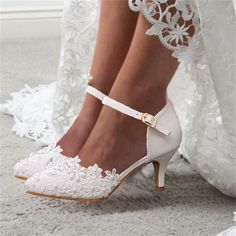 a close up of a person's shoes on the ground with lace and flowers