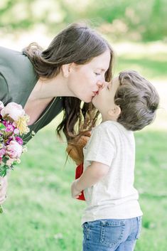 a woman kissing a small child on the cheek