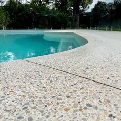 an empty swimming pool surrounded by trees and rocks