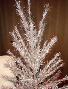 a silver tinsel christmas tree sitting on top of a table