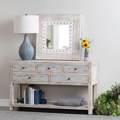 a dresser with a mirror and vase on top of it next to a book shelf