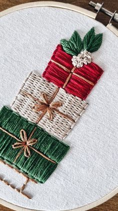 a close up of a embroidery on a piece of cloth with christmas presents in it