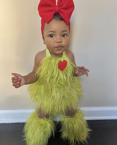 a young child dressed in a green monster costume with a red heart on it's chest