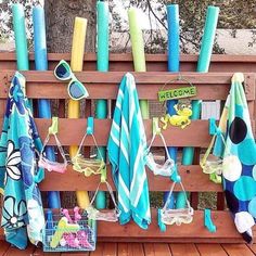 an umbrella and towels are hanging on a wooden rack