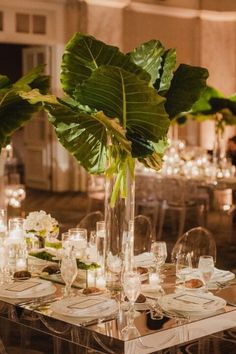 the table is set with plates, glasses and vases