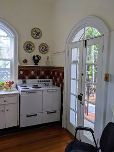 an old fashioned kitchen with white appliances and wood flooring is pictured in this image