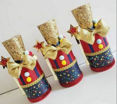 three red and blue tin canisters with gold stars on them, one is wearing a top hat