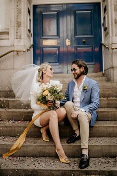 a bride and groom sitting on the steps