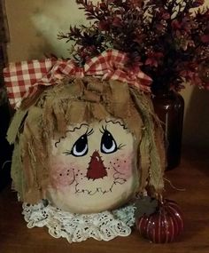 a scarecrow head sitting on top of a table next to a potted plant