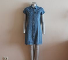 "Front Button Vintage Denim Dress Mini Denim Dress Jeans Dress Button Up Dress Short Sleeve Shirt Dress Grunge Denim Dress Small Label size: 160, estimated SMALL Measurements(lying flat): Shoulder: 14\"/ 35.5 cm Bust(pit to pit): 16.5\"/ 42 cm Sleeve: 5.5\"/ 14 cm Waist: 15 3/4\"/ 40 cm Length: 36\"/ 91.6 cm Please check measurements to insure a proper fit. Remember to allow yourself some extra room for movement. You can compare these with something from your closet that fits you well. Please co Denim Blue Cotton Dress With Buttons, Knee-length Denim Blue Dress With Buttons, Fitted Chambray Denim Dress With Short Sleeves, Knee-length Denim Dress With Buttons, Fitted Denim Shirt Dress With Buttons, Collared Light Wash Dress With Buttons, Fitted Denim Blue Shirt Dress With Buttons, Light Wash Collared Dress With Buttons, Knee-length Cotton Denim Dress With Button Closure