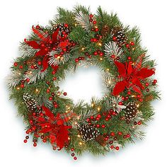 a christmas wreath with pine cones, red berries and lights on the front is shown