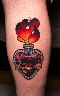 a man's leg with tattoos on it and a heart shaped object in the middle