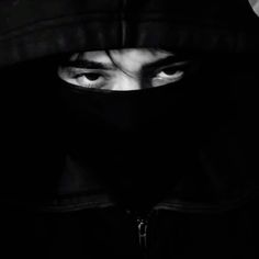 a person wearing a hooded jacket and covering their face with a hood over his head