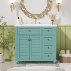 a bathroom with green walls and white counter top, gold mirror above the sink and blue cabinet