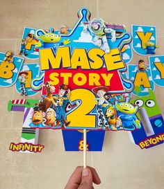 a hand holding up a toy story book with the title mase story 2 on it