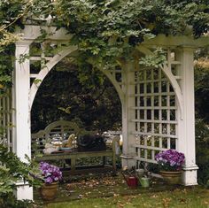 an arbor with flowers and potted plants on it