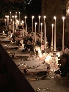 a long table is set with candles and flowers for an elegant dinner or wedding reception