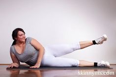 a woman in grey shirt and white leggings laying on the floor with her legs crossed