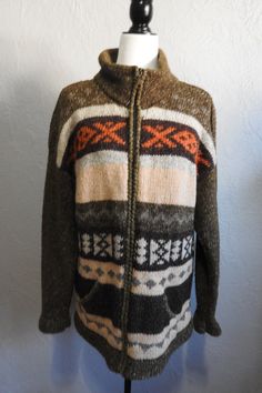 !00%  Wool handknit Ecuadorian  Sweater Cardigan by the Artisan group of Inti Ravmi.  The earth tones of Mossy Green, Browns,  Burnt Orange and Beiges show beautifully with the Incan inspired design. This will surely keep you warm on those chillier days. There is no tag for size, but looks like a Women's size large, or even a Men's size small. The collar can be zipped right up to the neck and there are 2 pockets in the front of sweater.  Length:29 inches Sleeves: 22 inches long Width: 48-inch ci Casual Knit Sweater Coat With Fair Isle Pattern, Casual Fair Isle Knit Sweater Coat, Warm Brown Cardigan For Cold Weather, Bohemian Knit Cardigan With Fair Isle Pattern, Bohemian Fair Isle Knit Cardigan, Cozy Knit Outerwear With Fair Isle Pattern, Cozy Knit Sweater Coat With Fair Isle Pattern, Brown Knitted Winter Sweater, Fair Isle Knit Cardigan For Cold Weather