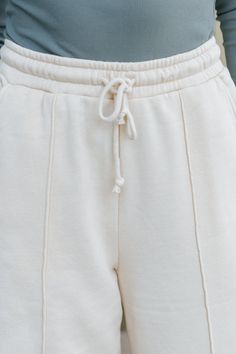 Elevate your loungewear with the effortlessly chic Cream Seam Detail Wide Leg Sweatpants! Designed with a high waisted fit, these sweatpants offer a flattering silhouette and all-day comfort. The elastic waistband and adjustable drawstring ensure a perfect fit while adding a casual, laid-back vibe. Featuring a sleek seam detail, these pants bring a touch of structure to the relaxed wide leg silhouette. The relaxed fit makes them ideal for lounging or running errands in comfort and style. Revival Clothing, Fall Style Guide, Gameday Dress, Loungewear Dresses, Wide Leg Sweatpants, Casual White Dress, Game Dresses, Blazer Coat, Black Maxi Dress