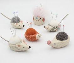 five hedgehogs with different colored hair on their backs and tails, all sitting side by side