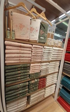 a display case filled with lots of folded and un - folded sheets in a store