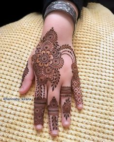 a woman's hand with henna tattoos on it