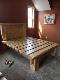 a bed frame made out of wood in a bedroom