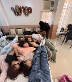 four people laying on top of each other in a living room