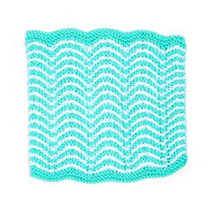 a blue and white crocheted dishcloth with wavy waves on the front, against a white background