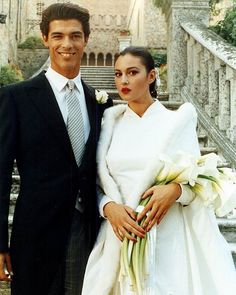 a bride and groom posing for a photo in front of an old building with stairs