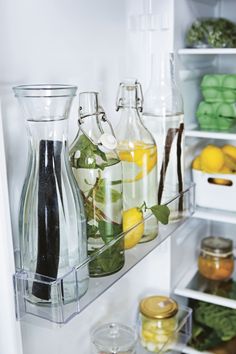 an open refrigerator filled with lots of different types of drinks and condiments in glass containers