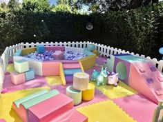 an inflatable play area with pink, yellow and blue blocks on the ground