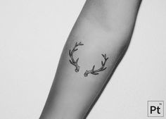 a black and white photo of a deer's antlers tattoo on the arm