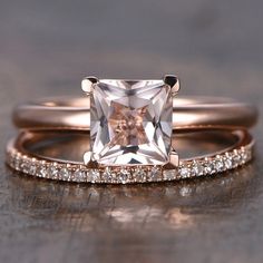 an engagement ring with a princess cut diamond in the center and side stones on each band