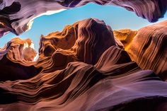 the inside of a rock formation with blue sky in the backgrounnds