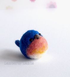 a small blue bird sitting on top of a white table