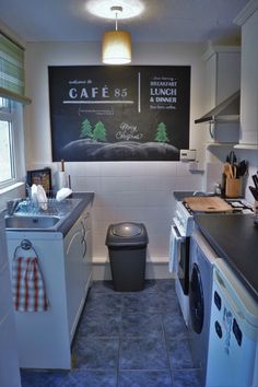 a kitchen with a black and white sign on the wall next to a washer and dryer