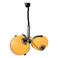 a yellow light fixture with two lamps attached to it