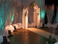 an outdoor wedding set up with white flowers and greenery on the side, surrounded by snow