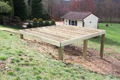 a wooden deck in the middle of a yard