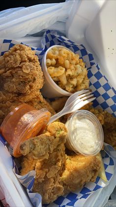 fried chicken with macaroni and cheese in a plastic container next to a fork