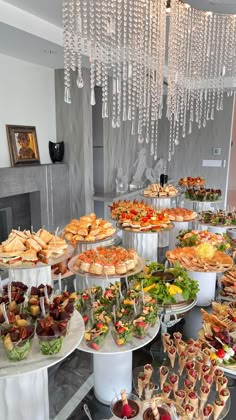 an assortment of desserts and pastries on display in a buffet style setting with chandelier hanging from the ceiling