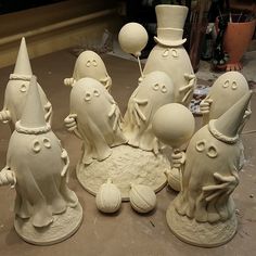 a group of white ceramic figurines sitting on top of a table next to each other