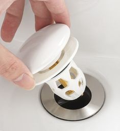 a person's hand is pressing the button on a sink faucet